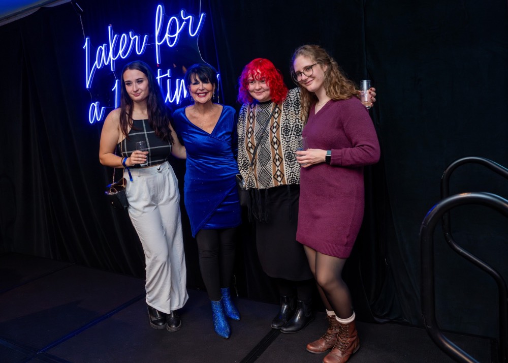 Group of three girls pose with President Mantella